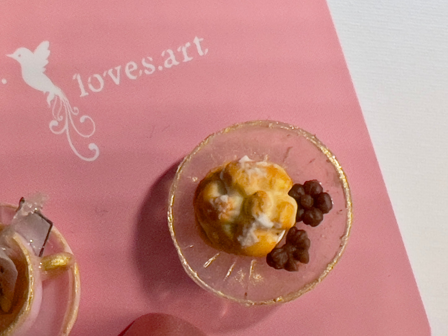 005 - Mini pink teacup with tea bag, white saucer with cream puff and chocolates