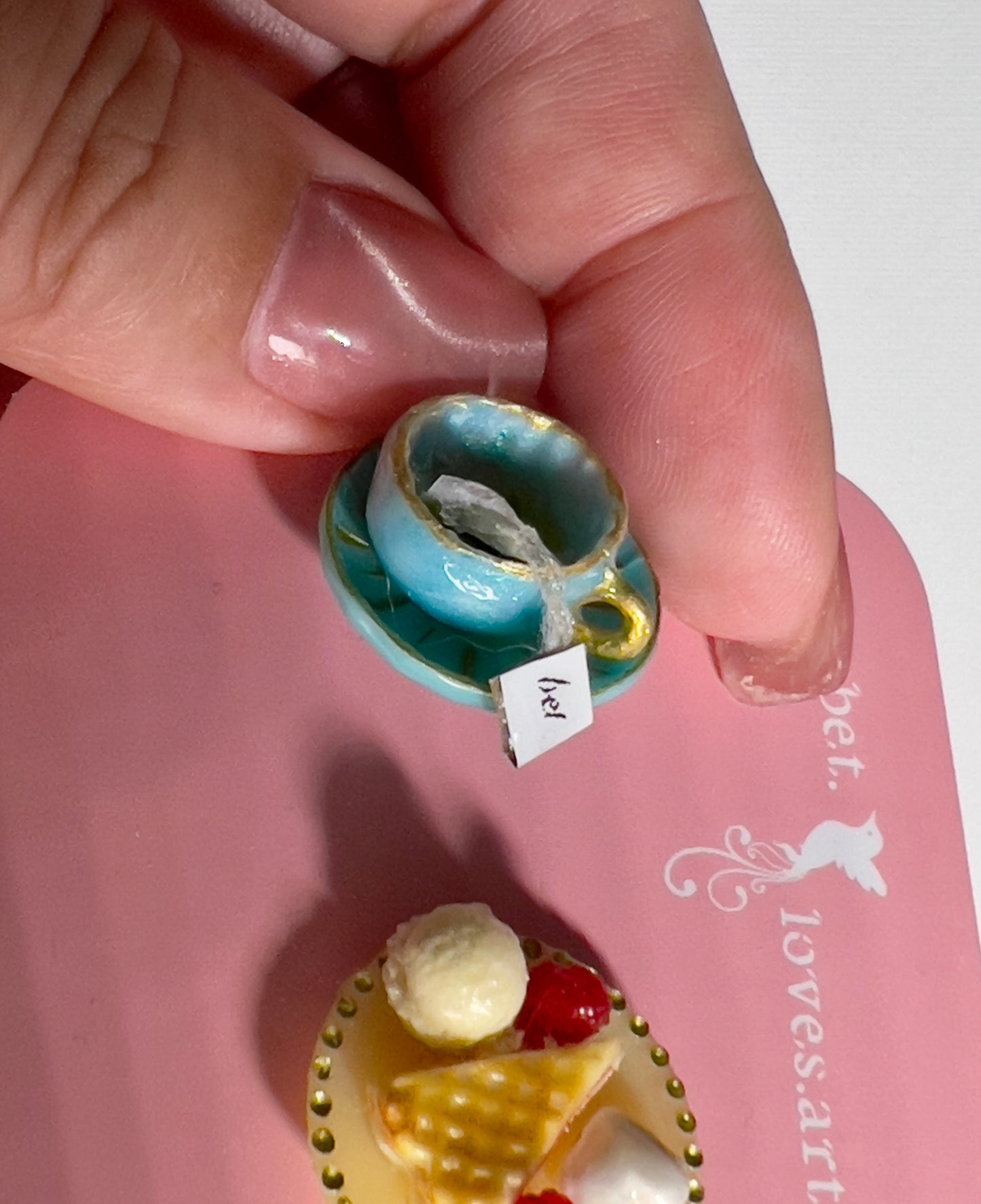 010 - Mini teal teacup with tea bag, waffle, raspberries, macaroon and vanilla ice cream on yellow saucer