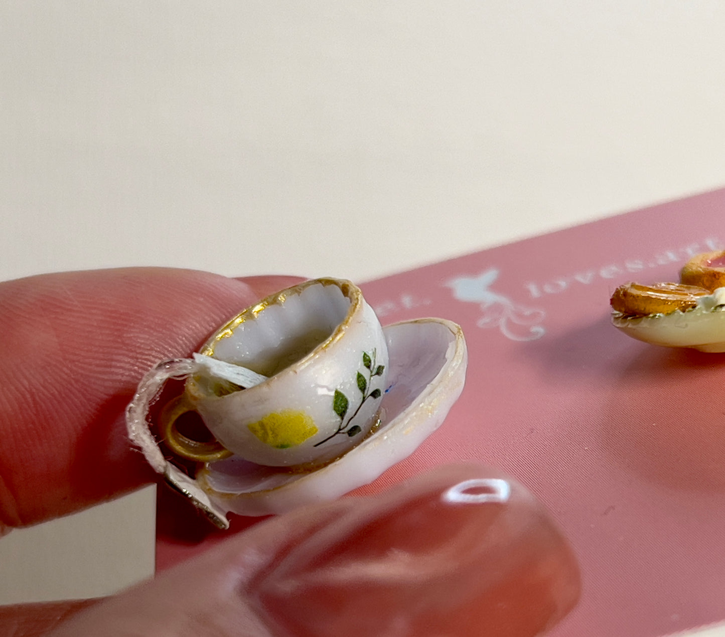 006 - Mini white teacup with tea bag, cookies on yellow saucer