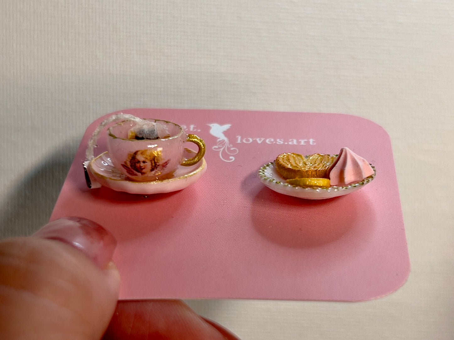 004 - Mini pink teacup with tea bag, palmiers and meringue on white saucer
