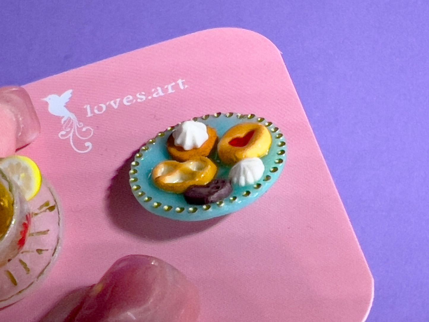 016 - Mini white opaque teacup and teal saucer of cookies