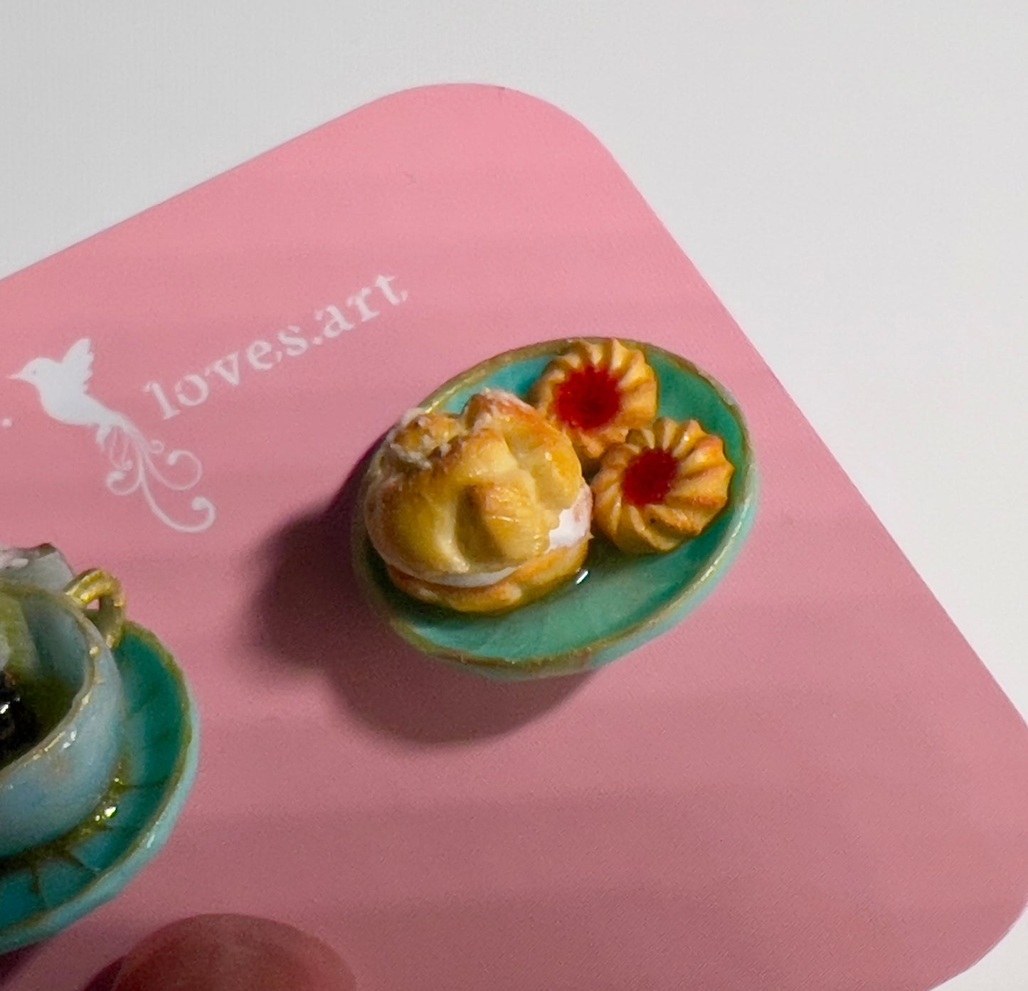 002 - Mini teal teacup with tea bag, teal saucer with cream puff and two cookies