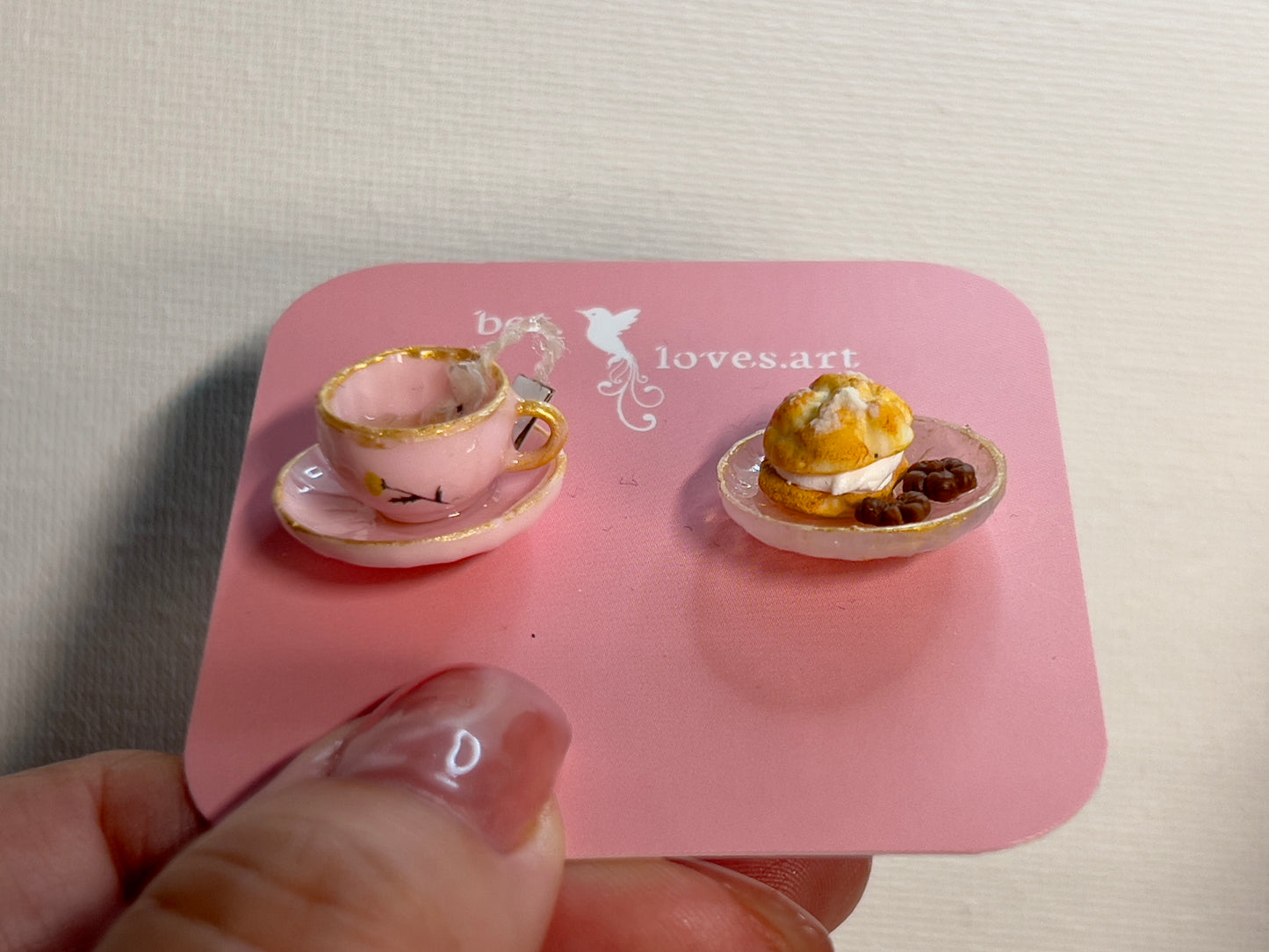 005 - Mini pink teacup with tea bag, white saucer with cream puff and chocolates