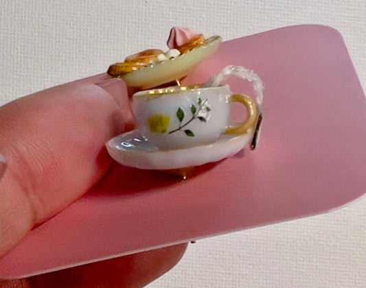 006 - Mini white teacup with tea bag, cookies on yellow saucer