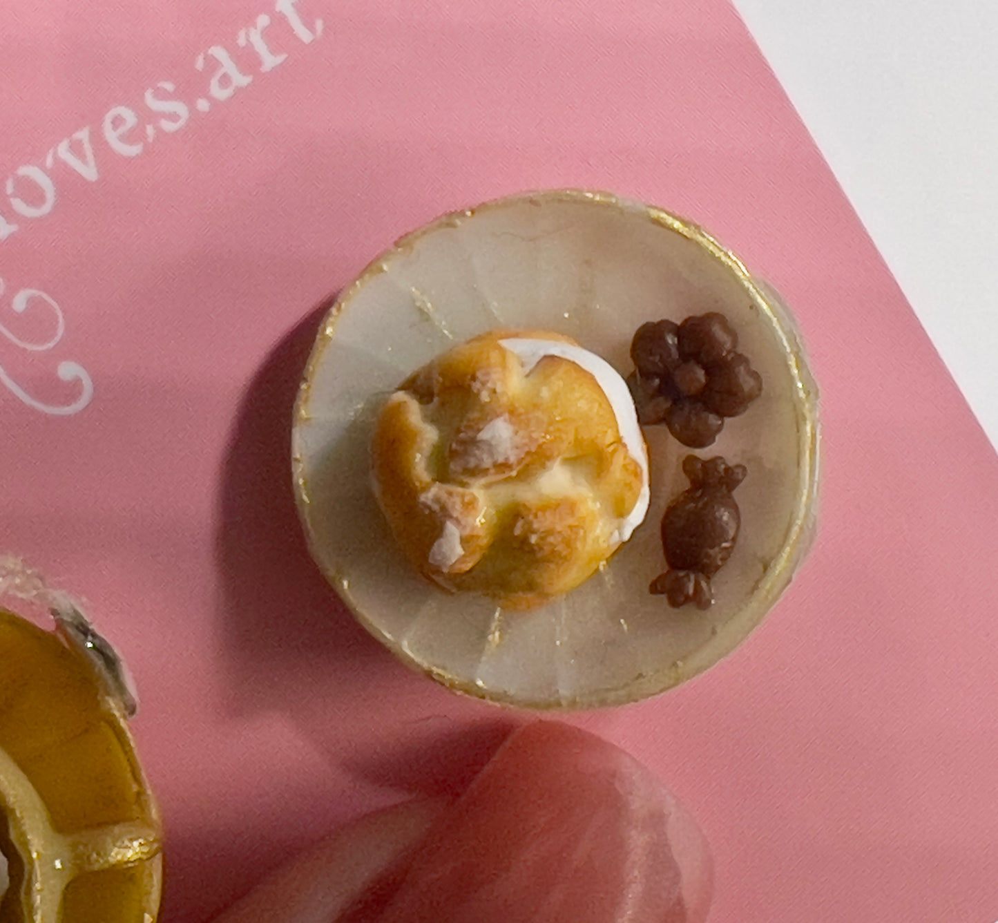003 - Mini yellow teacup with tea bag, cream puff and chocolates on white saucer